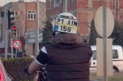 Ceza yememek için plakayı kaskına bantladı